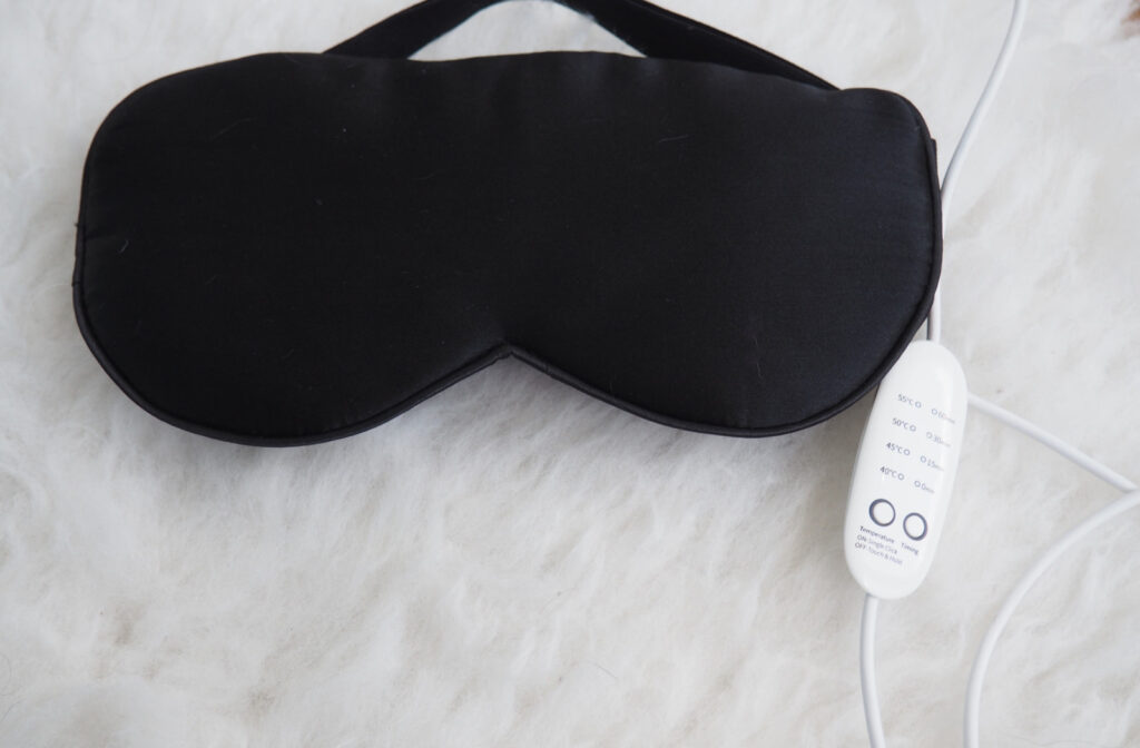A black heated eye mask against a white background.
