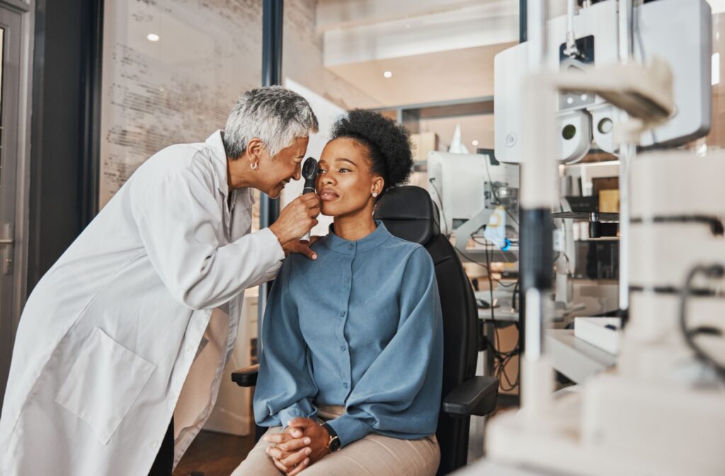 a female optometrist examines a young adult woman's eye in an eye exam in a modern office