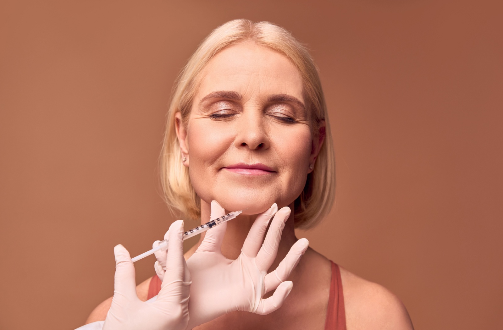 An older adult getting an injection to help with marionette lines.